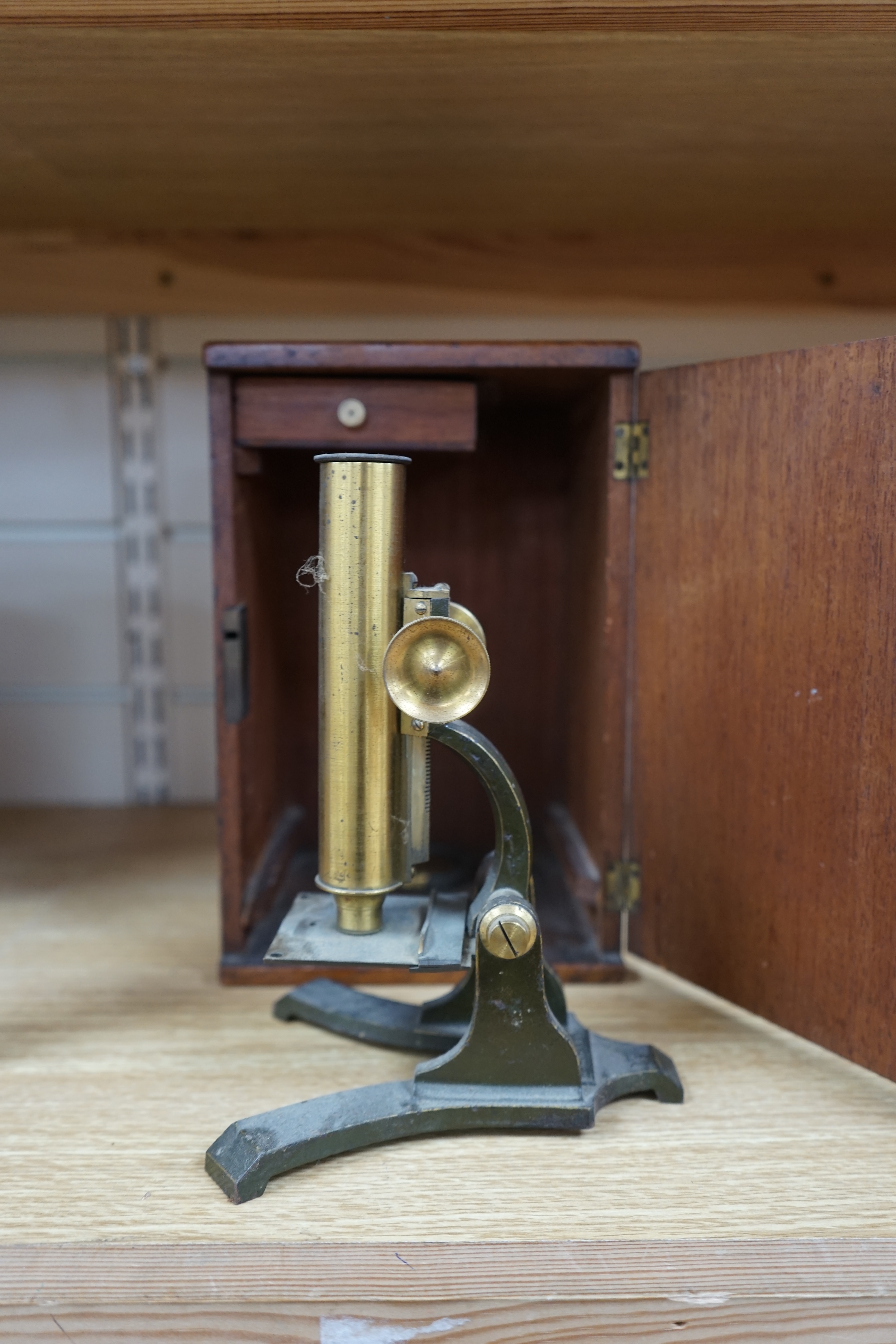 A Victorian brass microscope, J T Slugg, Manchester, in original wooden case, with a small selection of slides. Condition - fair, untested